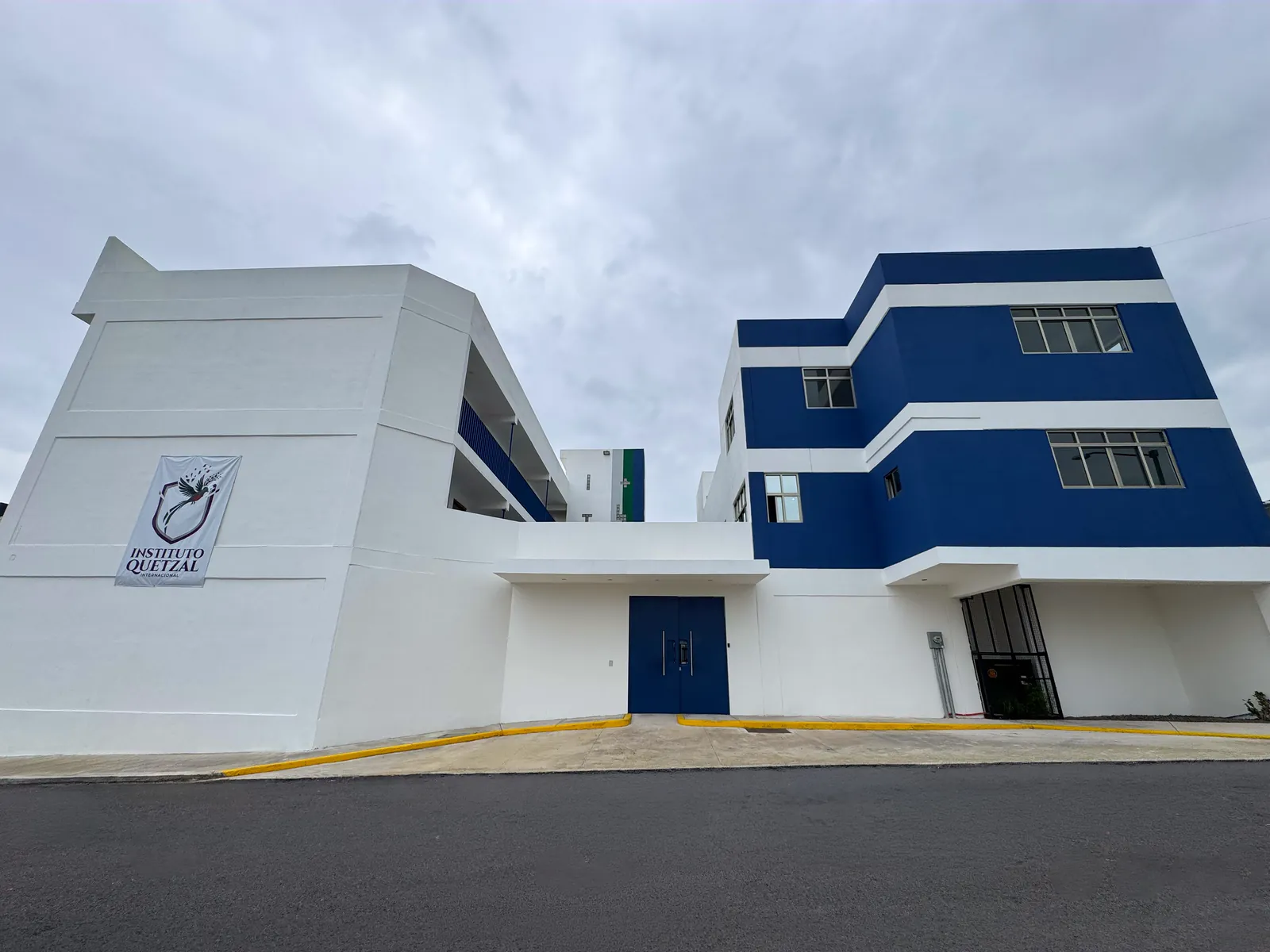 Fachada del Instituto Quetzal con el edificio azul y el acceso principal