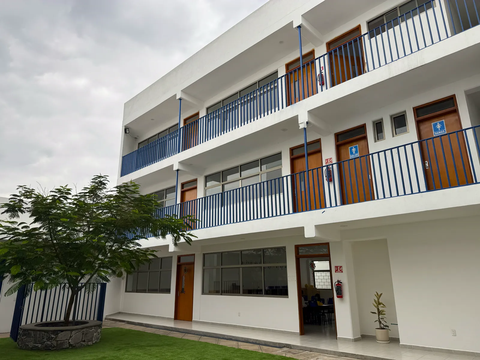 Edificio de salones de tres niveles con balcones azules