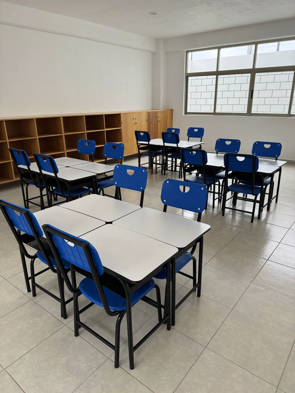 Salón con mesas agrupadas y libreros de madera