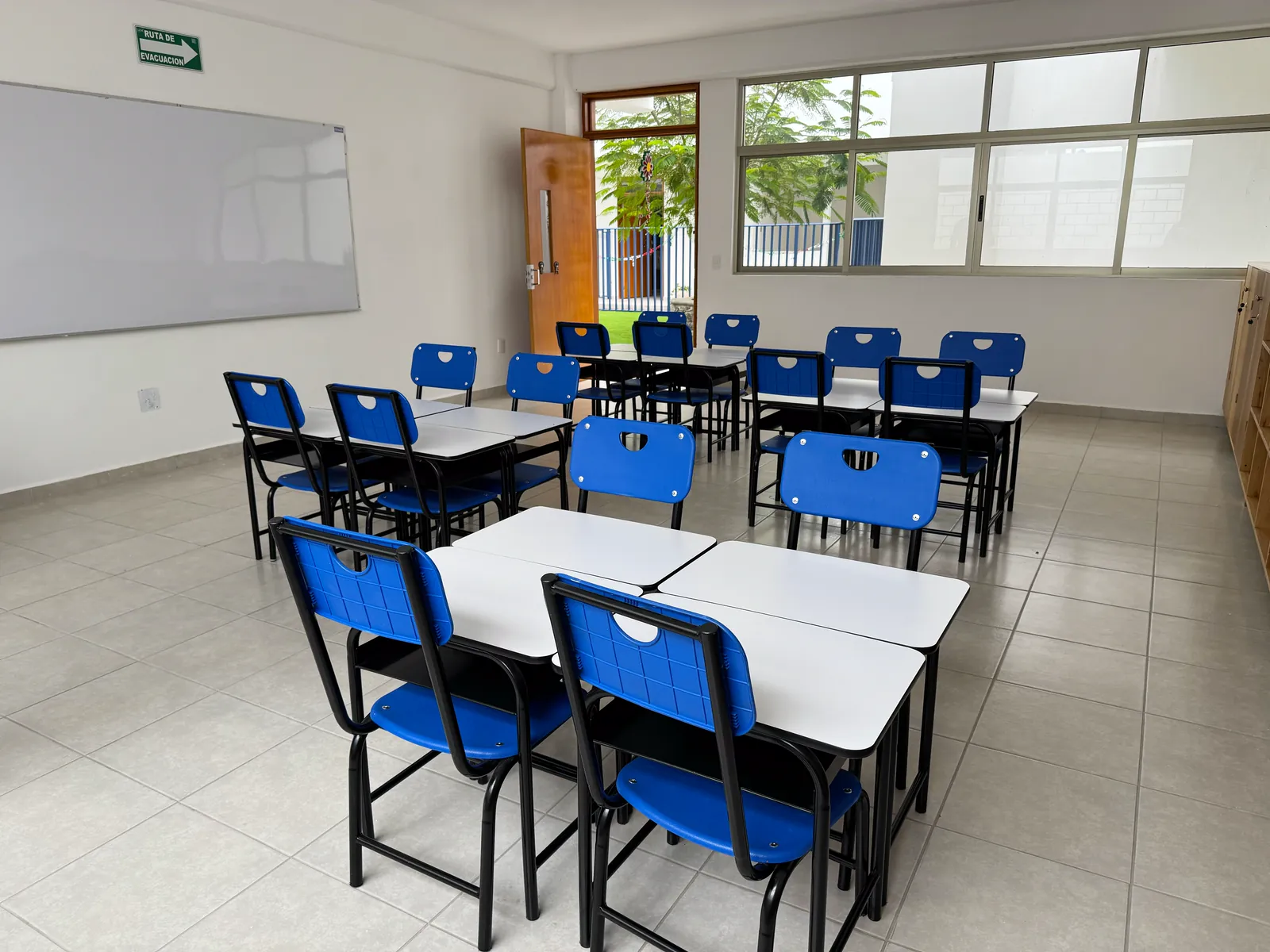 Salón con ventanales, mesas y sillas azules