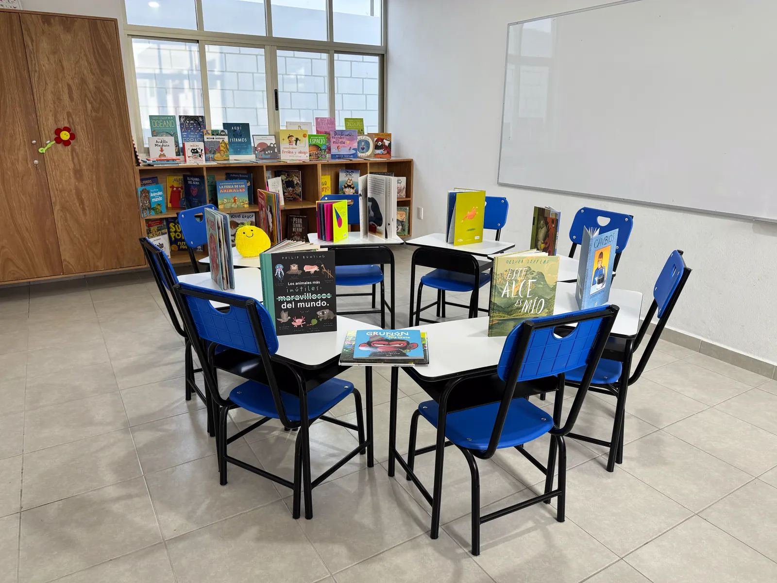 Mesas con libros infantiles y librero al fondo