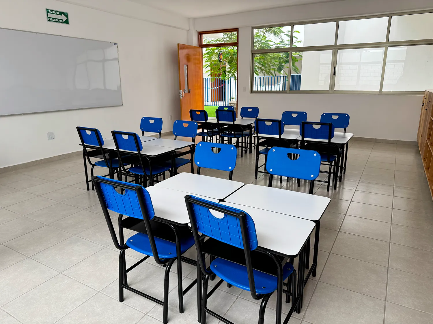 Sal&oacute;n del Instituto Quetzal con mesas agrupadas para trabajar en equipo